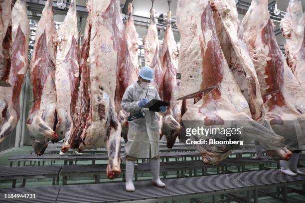 Worker takes notes while checking Kobe beef certified by the Kobe Beef Marketing and Distribution Promotion Association in a refrigerated storage...