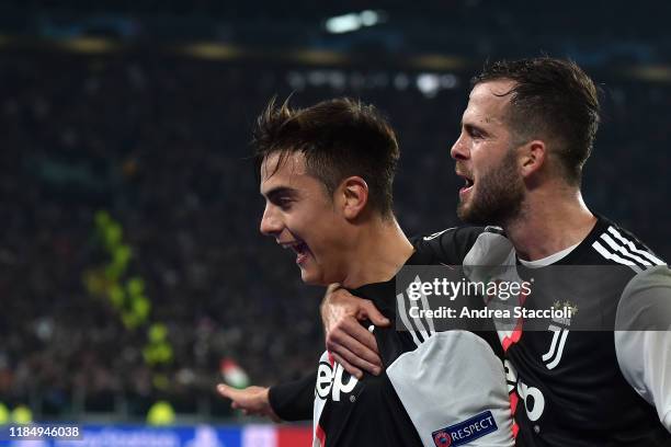 Paulo Dybala of Juventus celebrates with Miralem Pjanic after scoring the victory goal during the champions league Group D football match between...