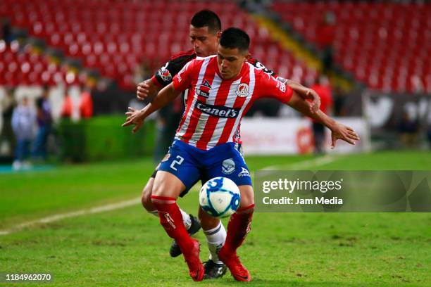 Osvaldo Martinez of Atlas fights for the ball with Juan Castro of San Luis during the 17th round match between Atlas and Atletico San Luis as part of...