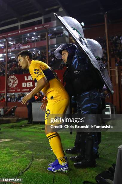 Mauro Zarate of Boca Juniors is shielded by riot police as he prepares to take a corner kick during a match between Lanús and Boca Juniors as part of...