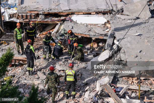 Italian search and rescue workers look for survivors stuck under the rubble of a collapsed building in the town of Durres, western Albania on...
