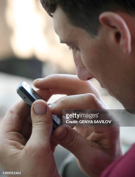 Leonid Stadnyk uses a mobile phone at his house in Podoliantsi village, 180 km from Kiev, 11 August 2007. Leonid Stadnyk, a giant veterinary surgeon...