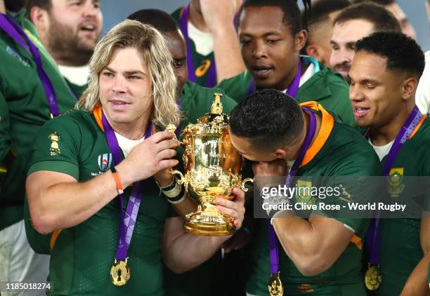 Faf de Klerk and Cheslin Kolbe of South Africa celebrate with the Web Ellis cup following their team's victory against England in the Rugby World Cup...