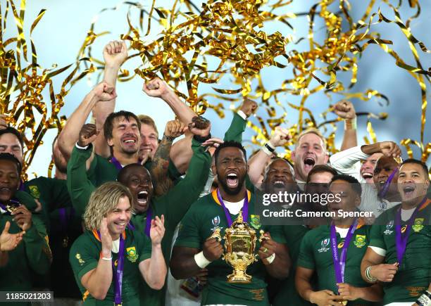 Players of South Africa celebrate as Siya Kolisi of South Africa lifts the Web Ellis Cup following their victory against England in the Rugby World...