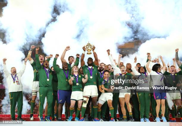 Players of South Africa celebrate as Siya Kolisi of South Africa lifts the Web Ellis Cup following their victory against England in the Rugby World...