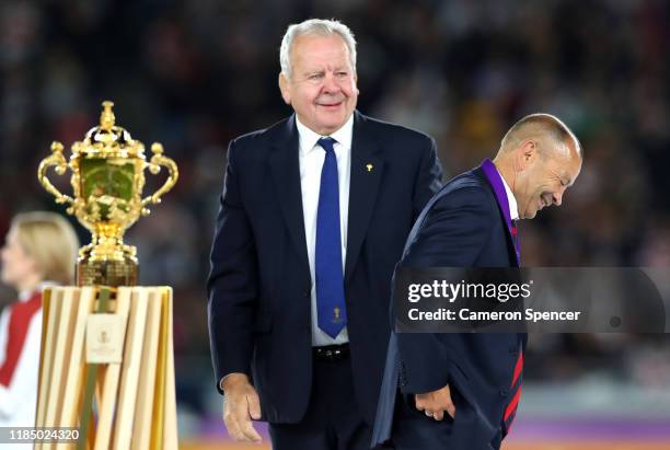 Bill Beaumont, Chairman of World Rugby looks on as Eddie Jones, Head Coach of England reacts as he walks past the Web Ellis cup after collecting his...