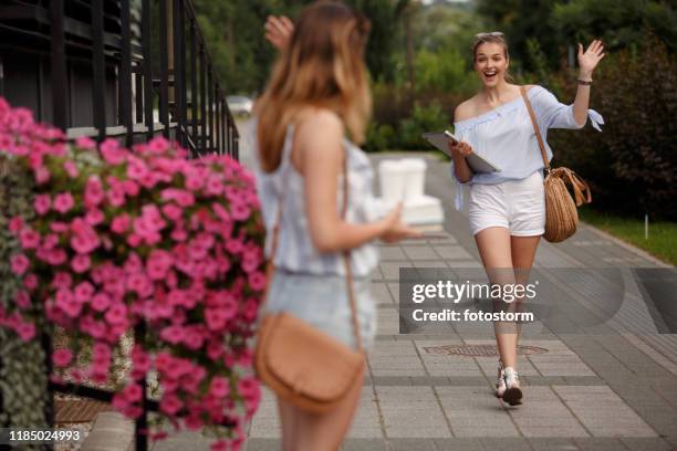 friends greeting each other on the street - female waving on street stock pictures, royalty-free photos & images