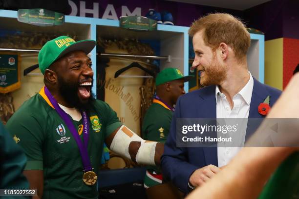 In this handout image provided by World Rugby Prince Harry, Duke of Sussex shares a joke with Tendai Mtawarira of South Africa following his team's...