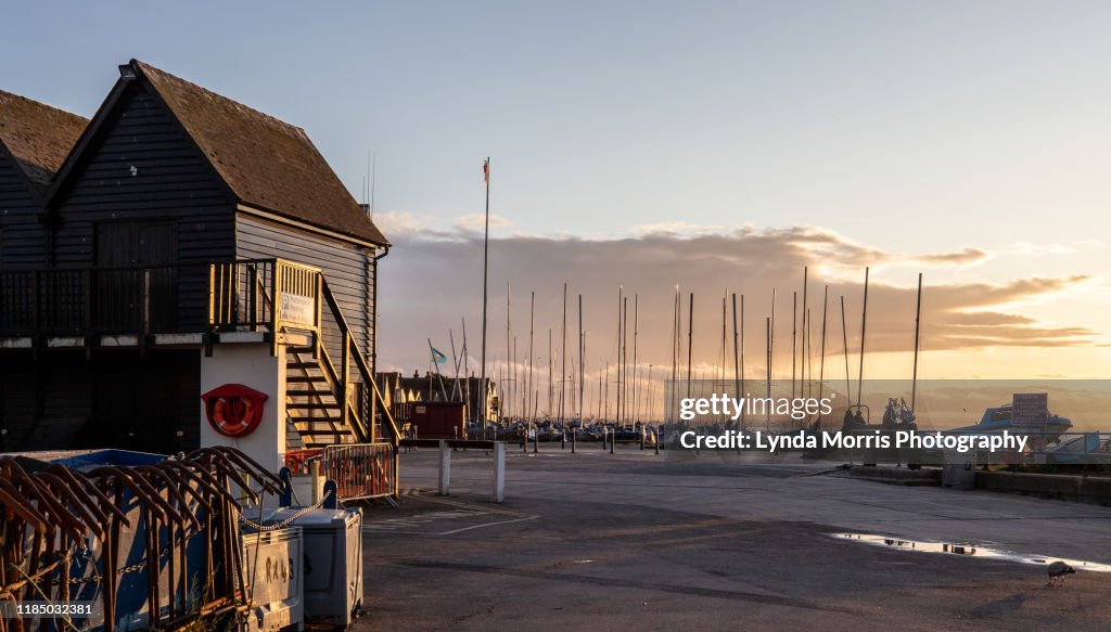 Whitstable Kent - Lifeboat house and sailing boats moored on the beach