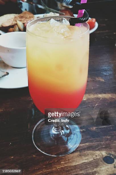 close-up of a tequila sunrise cocktail on a table - tequila sunrise stockfoto's en -beelden