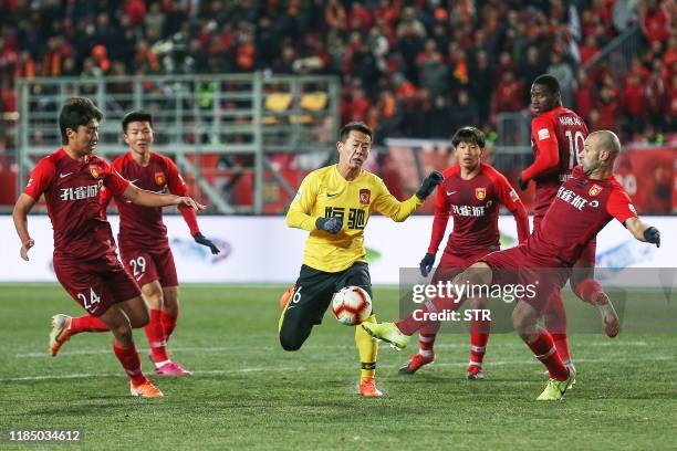 Guangzhou Evergrande's Huang Bowen fights for the ball with Hebei China Fortune's Javier Mascherano during their Chinese Super League football match...