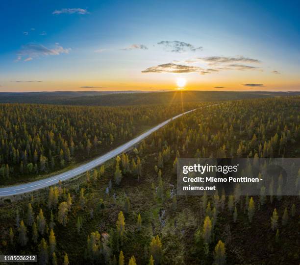 aerial view of the midnight sun shining over a remote road in the finnish lapland - lapland finland stock pictures, royalty-free photos & images