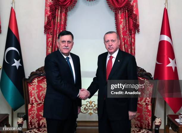 President of Turkey, Recep Tayyip Erdogan shakes hands with chairman of the Presidential Council of Libya, Fayez Al-Sarraj as they pose for a photo...