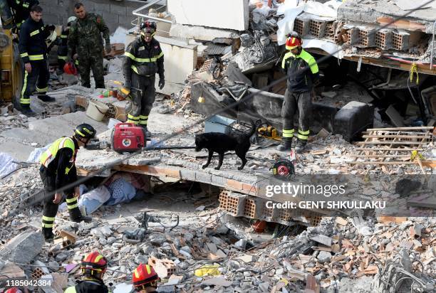 Italian rescuers search for survivors through the rubble of a collapsed building on November 27, 2019 in Thumane, northwest of the capital Tirana,...