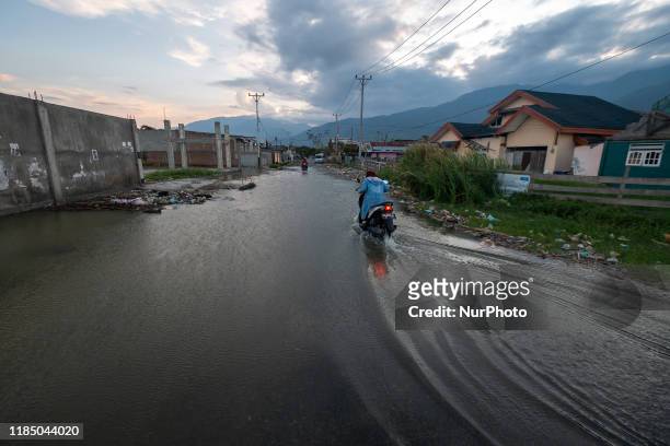 Motorbike riders break into a flood of tidal flooding in Kampung Lere, Palu, Central Sulawesi, Indonesia, on November 27, 2019. The high tide caused...