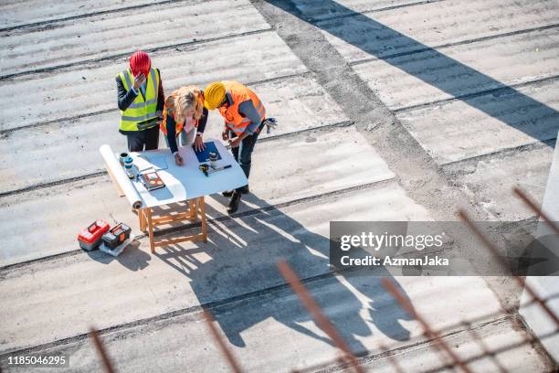 construction team standing at planning table and talking - program manager stock pictures, royalty-free photos & images
