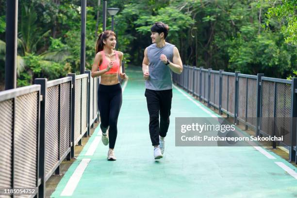 couple woking out at public park - asian six pack photos et images de collection