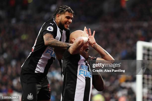 Jonjo Shelvey of Newcastle United celebrates with teammate Deandre Yedlin after scoring his team's third goal during the Premier League match between...