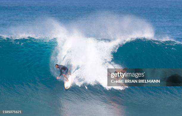 Hawaii's pro surfers Bruce Irons and Eli Olson ride a wave during the Vans World Cup of Surfing at Backdoor Pipeline on the north shore of Oahu on...