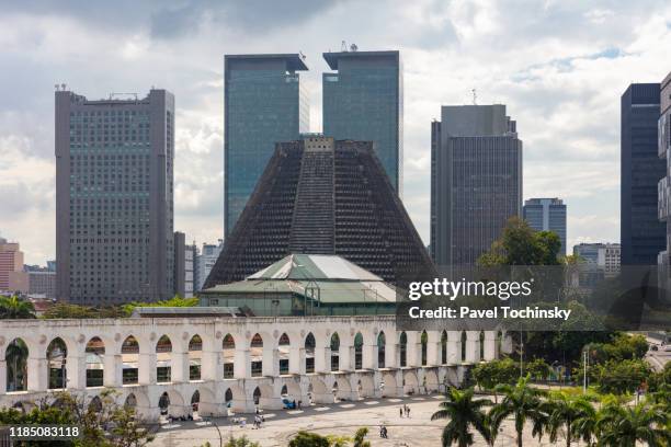 distinctive catedral metropolitana de são sebastião do rio de janeiro opened in 1979 with rio's downtown district in the background, brazil - zuckerhut form stock-fotos und bilder