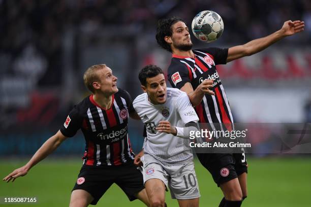 Philippe Coutinho of Muenchen is challenged by Sebastian Rode and Goncalo Paciencia of Frankfurt during the Bundesliga match between Eintracht...