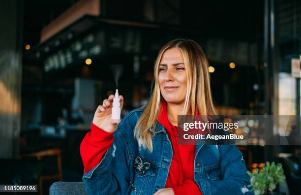 kranke frau mit nasenspray - nasenspray stock-fotos und bilder