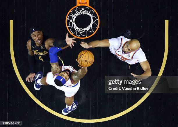 Rondae Hollis-Jefferson of the Toronto Raptors shoots the ball as Taj Gibson and Marcus Morris Sr. #13 of the New York Knicks defend during the first...