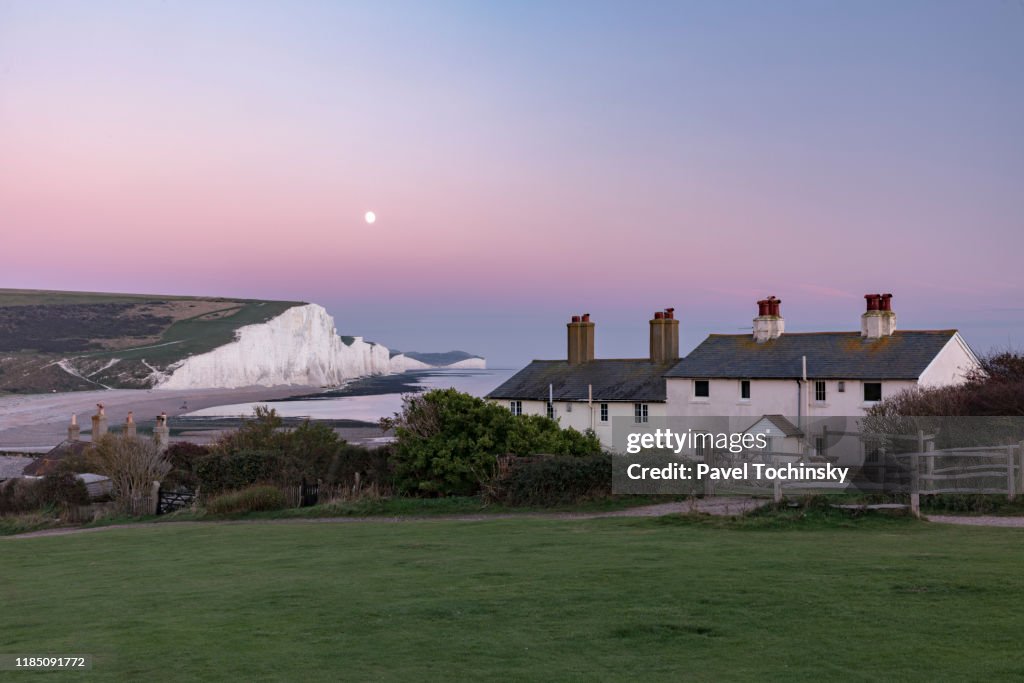 Famous Seven Sisters cliffs and coast guard cottages at sunset, located in East Sussex, England, 2018