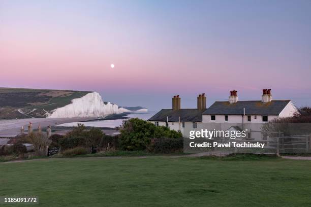 famous seven sisters cliffs and coast guard cottages at sunset, located in east sussex, england, 2018 - east sussex imagens e fotografias de stock