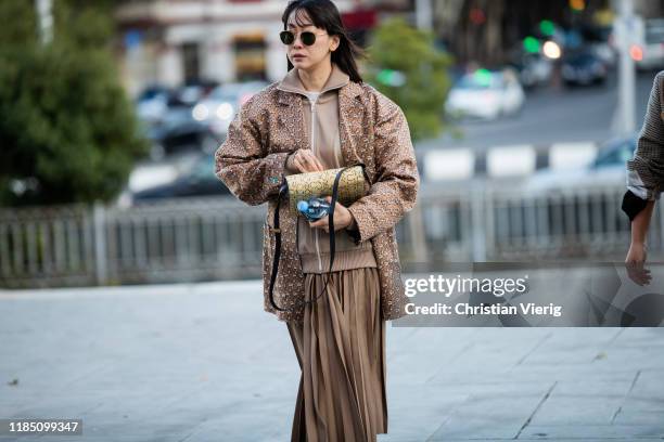 Guest is seen wearing brown jacket, track suit zipped jacket, pleated skirt during day 3 of the Mercedes-Benz Tbilisi Fashion Week on November 02,...