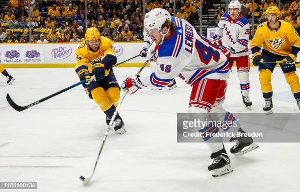 Brendan Lemieux of the New York Rangers flips a puck past Craig Smith of the Nashville Predators during the first period at Bridgestone Arena on...