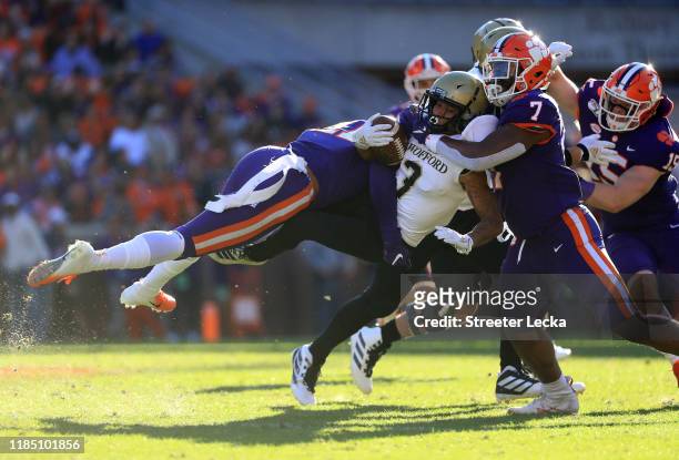 Teammates Isaiah Simmons and Justin Mascoll of the Clemson Tigers tackle D'mauriae VanCleave of the Wofford Terriers during their game at Memorial...