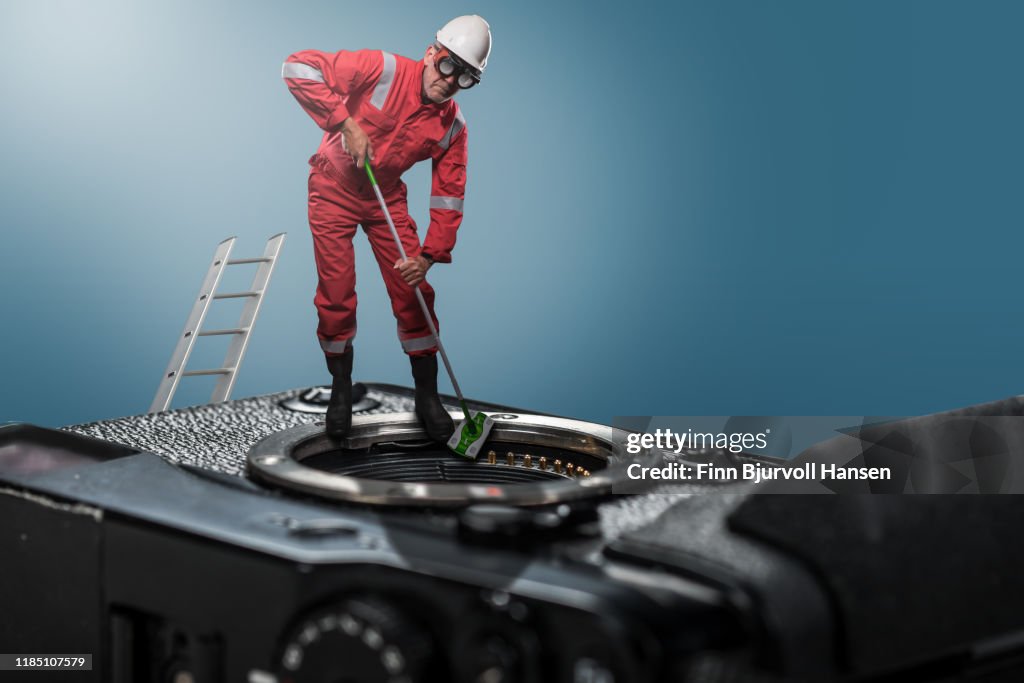 Technician standing on camera cleaning camera sensor