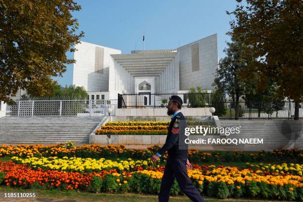 Policeman walks past in front of the Supreme Court building during a case hearing suspending the notification of the tenure extension of Chief of...