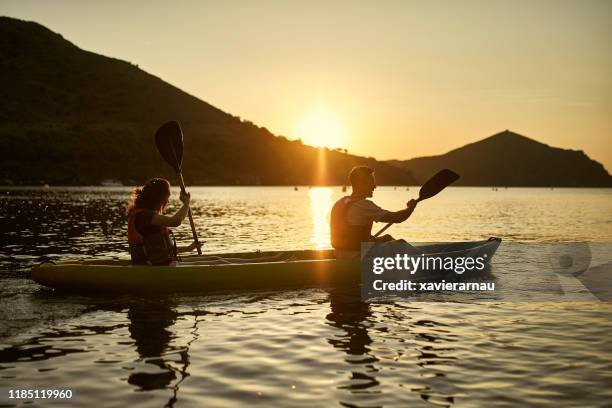 silhouetted kayakers paddling off the costa brava at dawn - 2 dramatic landscape stock pictures, royalty-free photos & images