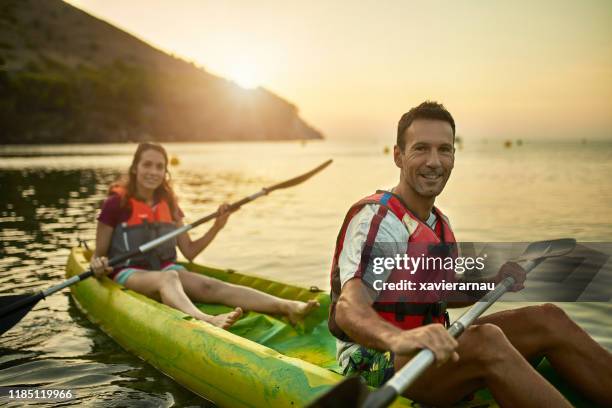 porträt der lächelnden spanischen tandem-kajakfahrer bei dawn - sea kayaking stock-fotos und bilder
