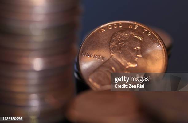 stack of us pennies with one facing camera showing image of abraham lincoln's profile - us penny stock pictures, royalty-free photos & images