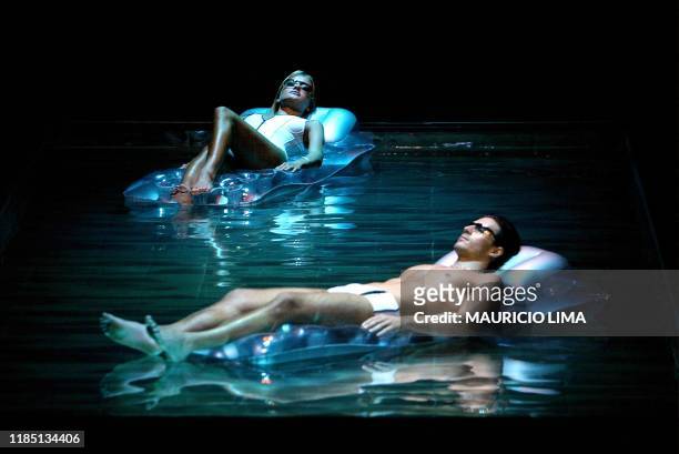 Models are seen in a pool during a fashion show in Sao Paulo, Brazil 31 January 2003. Dos modelos simulan tomar sol en una piscina, al inicio del...