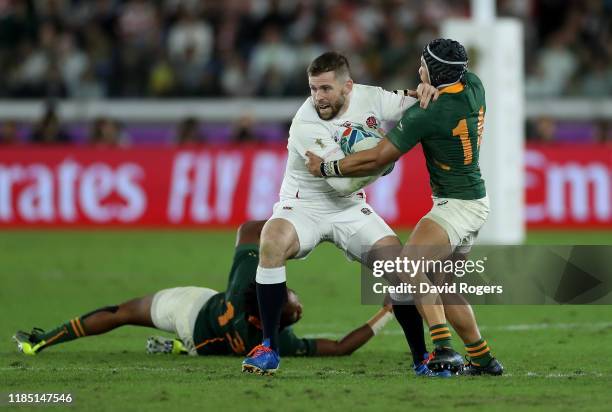 Elliot Daly of England is tackled by Cheslin Kolbe during the Rugby World Cup 2019 Final between England and South Africa at International Stadium...