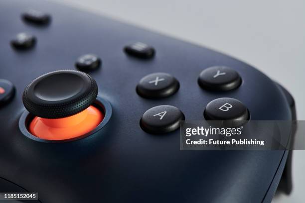 Close-up detail of the A B X Y buttons and analogue control stick on a Google Stadia video game controller with a Night Blue finish, taken on...