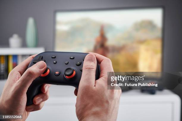 Detail of hands holding a Google Stadia video game controller, taken on November 27, 2019.