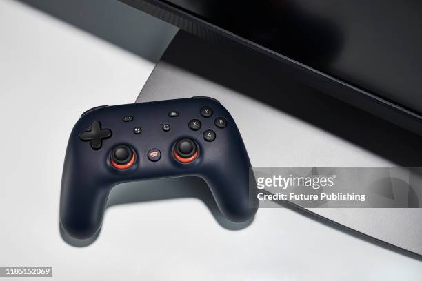 Google Stadia video game controller with a Night Blue finish alongside a gaming monitor, taken on November 27, 2019.