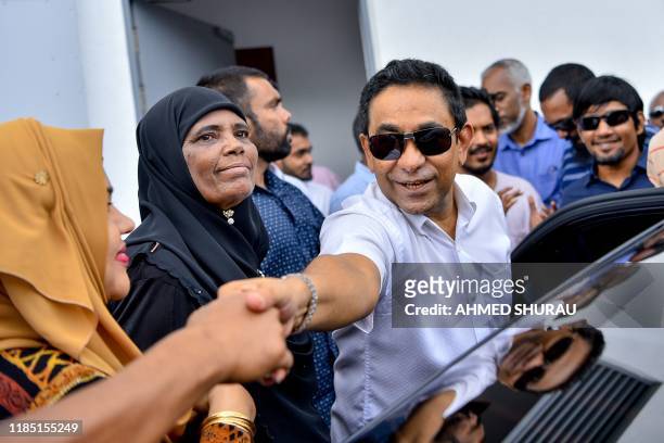 Maldives's former president Abdulla Yameen greets supporters as he arrives at a criminal court for his trial in Male on November 28, 2019. -...