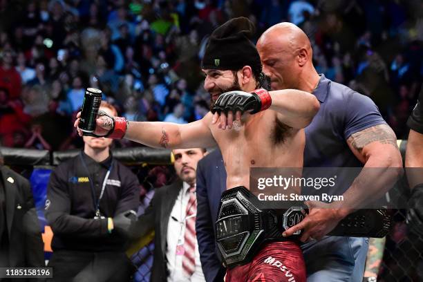 Jorge Masvidal of the United States is awarded the belt by Dwayne "the Rock" Johnson after his victory by TKO on a medical stoppage against Nate Diaz...