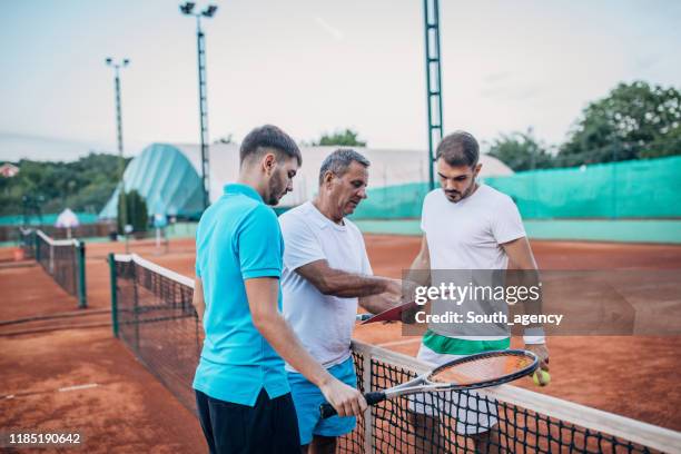 男性にテニスのレッスンを教えるコーチ - tennis coaching ストックフォトと画像