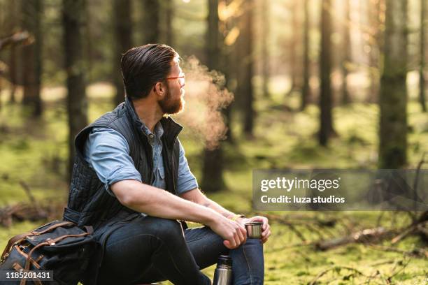 een individuele reiziger genieten van koffie in de scandinavische natuur - zichtbare adem stockfoto's en -beelden