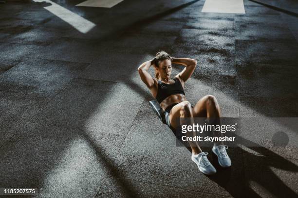 oben blick auf sportlerinnen, die sit-ups auf einem boden in einem fitnesscenter trainieren. - bauchmuskel stock-fotos und bilder