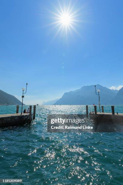 harbor entrance with sun, torbole, lake garda, lago di garda, trentino, italy - torbole stock pictures, royalty-free photos & images