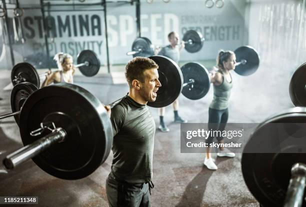 groep van atletische mensen met gewicht training met barbells in een health club. - snatch weightlifting stockfoto's en -beelden