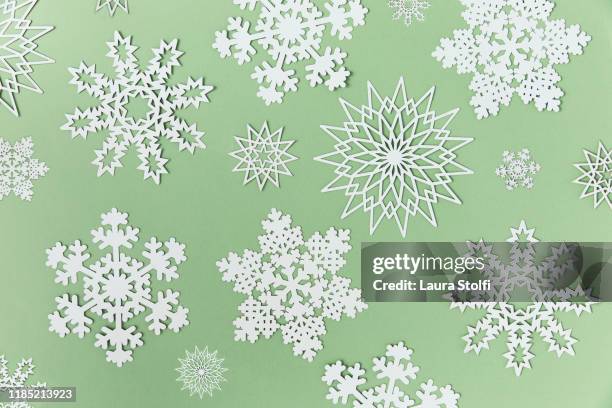 variation of snowflakes paper cut outs on top of green background - green christmas designs stock pictures, royalty-free photos & images